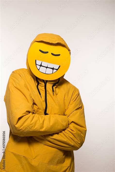 Guy with funny emoji mask and hoodie, big grin smiling face, man having ...