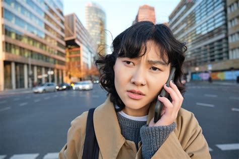 Feche o retrato de uma mulher asiática preocupada falando no celular e