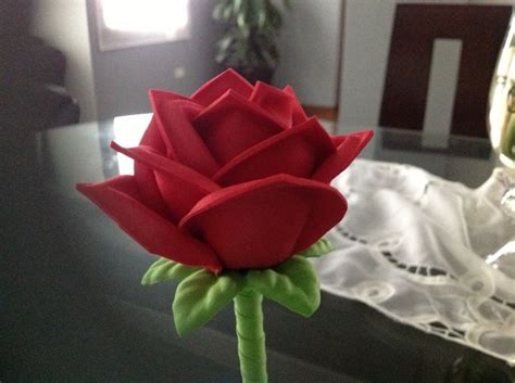 A Red Rose Sitting On Top Of A Table