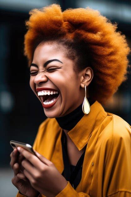 Foto de una mujer joven que se ríe mirando su teléfono celular creado