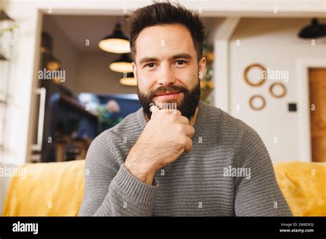 Portrait Of Biracial Bearded Young Man With Hand On Chin Smiling And