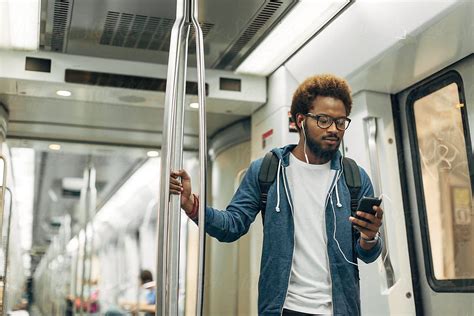 Young Afro Black Man Using Mobile Phone While Listening Music On The