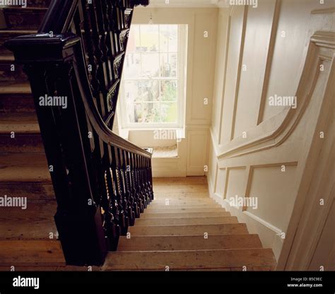 View Down Cream Paneled Georgian Staircase With Wooden Stairs And Dark