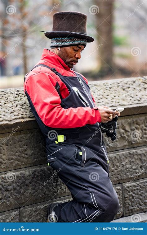 Man Leans Against Wall In Top Hat Reading His Smart Phone Editorial