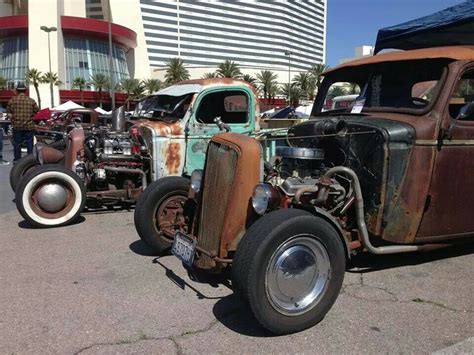 An Old Rusty Truck Parked In Front Of A Tall Building