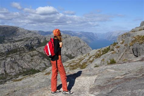 Excursionista chica de pie sobre una roca y mirando las montañas Foto