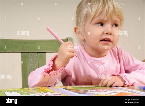 Stock foto de una niña de cuatro años dibujando sobre un trozo de papel