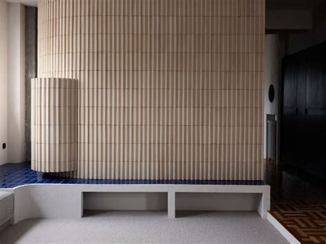 An Empty Room With A Bench And Tiled Wall