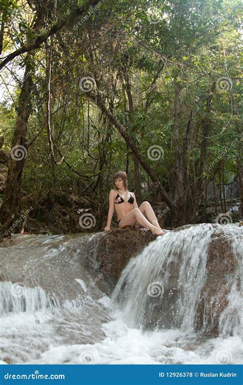 A Menina Senta se Na Pedra Na Cachoeira Foto de Stock Imagem de maiô