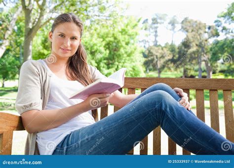 Mulher Que Senta Se Em Um Banco De Parque Um Livro Imagem De Stock