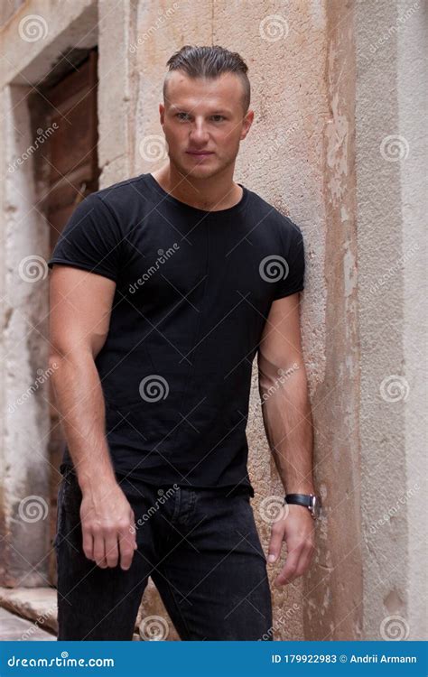 In Black Clothes Attractive Guy Leans Against The Wall Stock Image