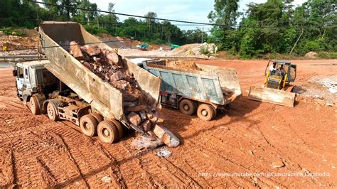 Huge Dump Trucks Unloading Stones And Bulldozer Clears Rocks For