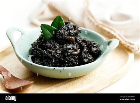 Stir Fried Squid And Chili In Black Squid Ink Sauce Served In Ceramic