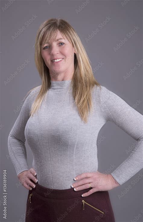 Attractive Middle Aged Busty Woman With Hands On Waist Wearing A Tight