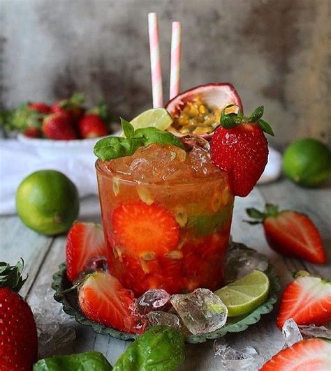 A Drink With Strawberries And Limes On The Table