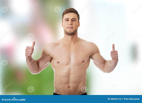 Hombre Muscular Atractivo Que Muestra Los Pulgares Para Arriba Foto De