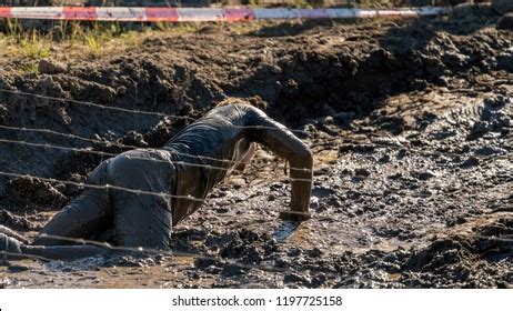 Athlete Crawling Under Barbed Wire Dirty Foto Stock 1197725158