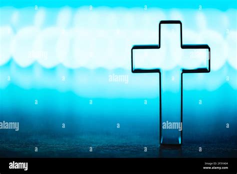 Christian cross on blue background with soft bokeh lights background ...