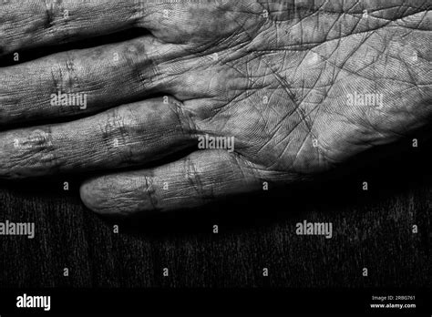 Black And White Picture Of Elderly Male Hands On A Dark Background