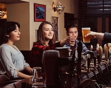 Jovens Amigos Multirraciais No Bar Barman Dando Copo De Cerveja Ao