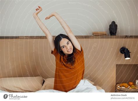 Smiling Woman Stretching Arms After Good Sleep On Bed A Royalty Free