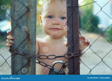 Upset Baby Looking Out Of Locked Wire Fencing Stock Photo Image Of