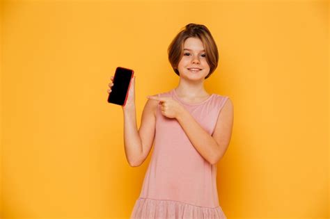 Lächelndes Mädchen das auf den leeren Bildschirm des Smartphone