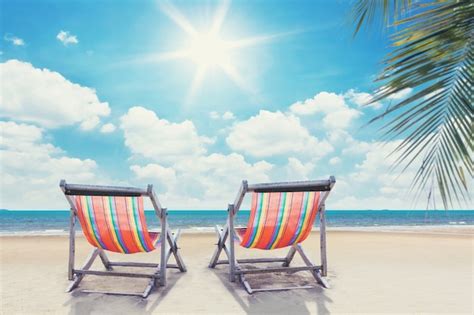 Premium Photo Two Beach Chairs On Palmbeach With Sunny Sky