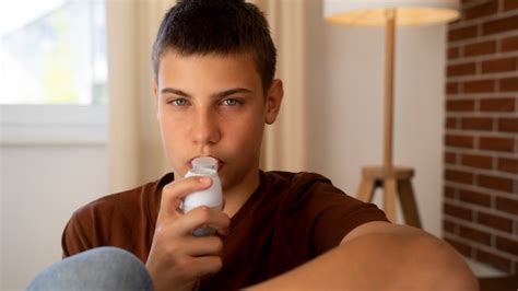 Vista Do Adolescente Usando Inalador Em Casa Para Problemas De Sa De