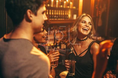 Young Woman Having Drink At Nightclub With Friends Jacob Lund