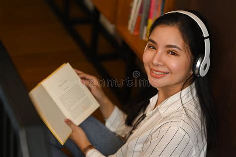 Happy Young Students Listening To Music And Reading Book In Modern