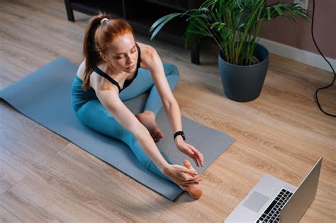 Top View Of Flexible Redhead Young Woman Working Out Doing Stretching Exercise On Yoga Mat