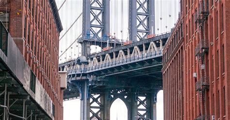 Brooklyn Bridge Seen between Buildings · Free Stock Photo