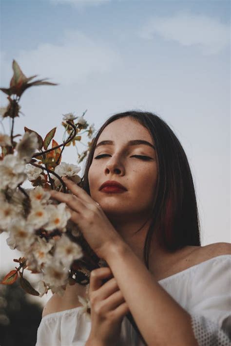 Woman in White Shirt Holding White Flower · Free Stock Photo