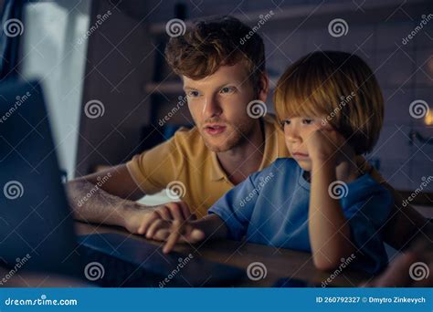 Pai E Filho Assistindo Um Movimento Antes De Ir Para A Cama Imagem De