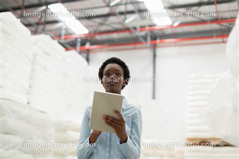 Front View Of Female Manager With Digital Tablet Checking Stocks In