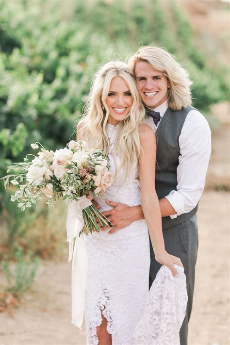 A Bride And Groom Hugging Each Other In The Desert