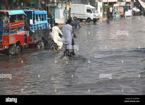 Commuters Pass Through The Stagnant Rain Water On The Road Near Kala