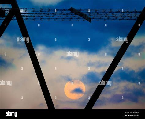 Una luna llena está apenas fijando visto a través de las vigas