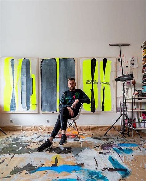 A Man Sitting On A Chair In Front Of Paintings