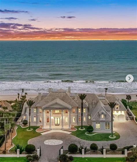 This Is An Aerial View Of A Home On The Beach At Sunset With Ocean In