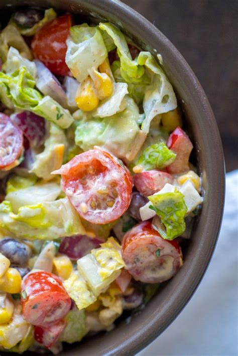 A Salad With Tomatoes Corn And Lettuce In A Bowl On A Table