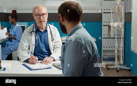 Médico De Cabecera Que Asiste A Un Examen De Salud Con Un Adulto Joven