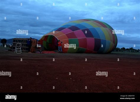 Process Of Inflation And Preparation Of Hot Air Balloon At Sunrise For Flight In Cloudy Sky