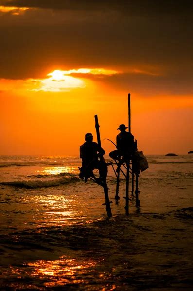 Siluetas De Los Pescadores Tradicionales Al Atardecer En Sri Lanka