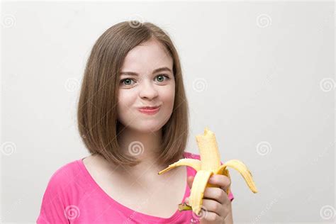 Portrait Of Smiling Caucasian Woman Girl Eating And Chewing Yellow