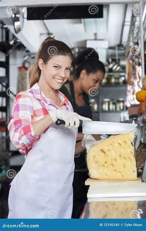 Happy Young Woman Slicing Cheese With Knife In Shop Stock Image Image