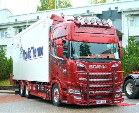 A Red Semi Truck Parked In Front Of A Building