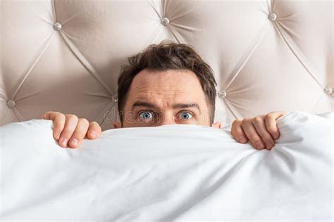 Caucasian Young Man Hiding In Bed Under The Blanket At Home Stock Image