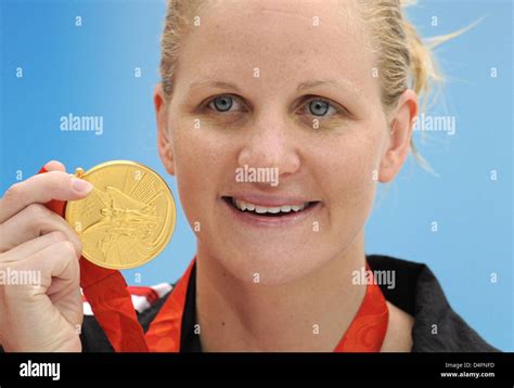 Kirsty Coventry Of Zimbabwe Shows Her Gold Medal After Winning The